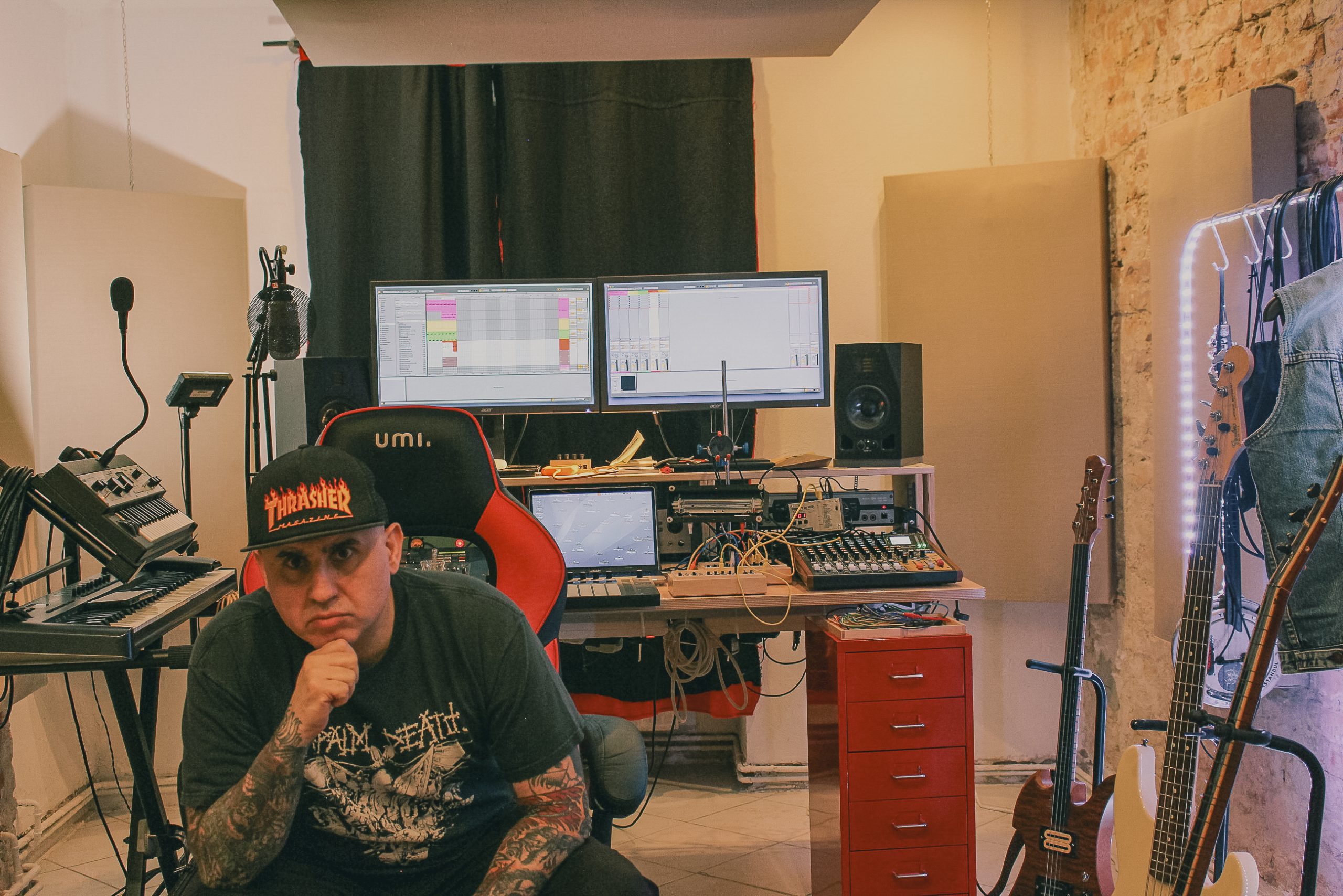 Volkan T sitzt im Musikstudio, im Hintergrund ist ein Mischpult und die Musik Hardware zu sehen.