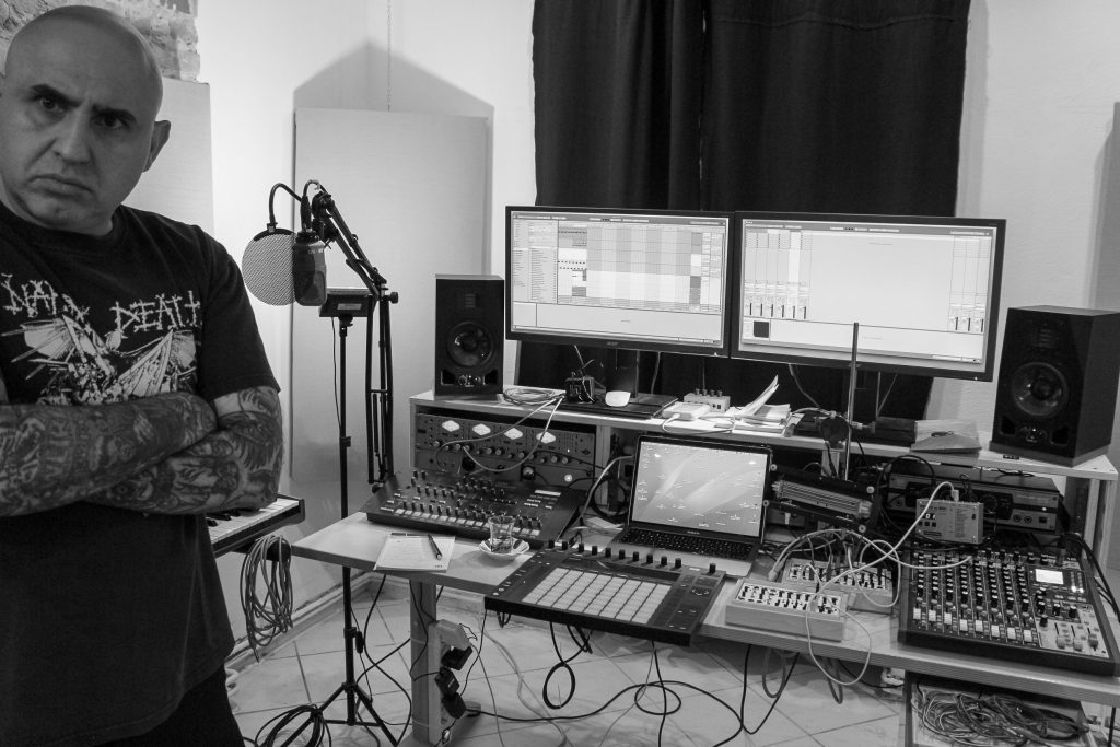 Volkan T steht links im Musikstudio, im Hintergrund ist ein Mischpult und die Musik Hardware zu sehen.